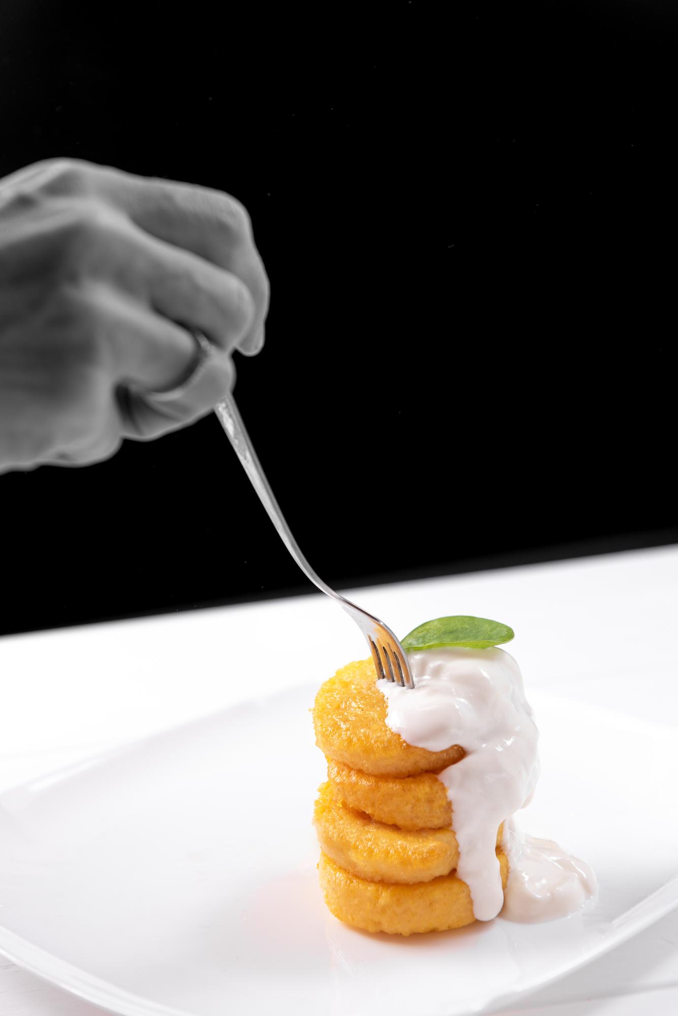 Chef hands arranging garnish under LED light
